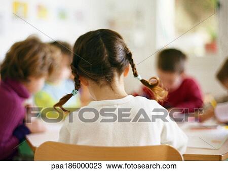 Stock Image - Children sitting at table, head and shoulders. Fotosearch
