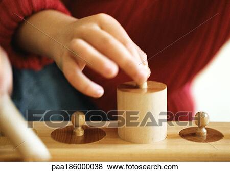 Child's hand holding wooden weight, close-up View Large Photo Image Stock Photo - Child's hand holding wooden weight, close-up. Fotosearch
