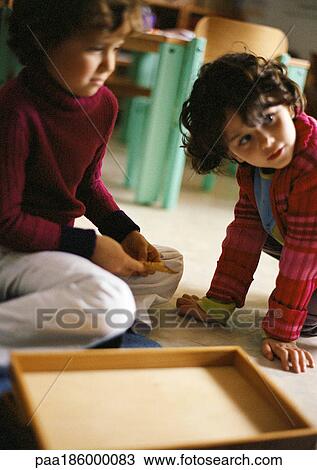 Two children on floor, close-up View Large Photo Image Stock Image - Two children on floor, close-up. Fotosearch
