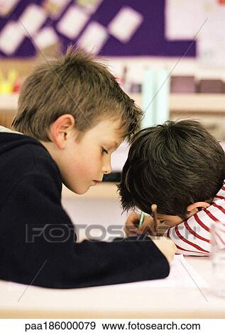 Two children writing on sheets of paper, side view View Large Photo Image Stock Photo - Two children writing on sheets of paper, side view. Fotosearch