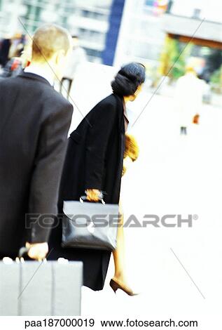 Businessman and businesswoman holding briefcases, rear view, blurred View Large Photo Image Stock Photo - Businessman and businesswoman holding briefcases, rear view, blurred. Fotosearch