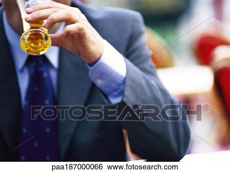 Stock Photograph - Businessman holding glass, outdoors, close-up. Fotosearch