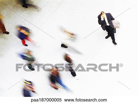 Stock Photography - Businessman in crowd, elevated view, blurred. Fotosearch
