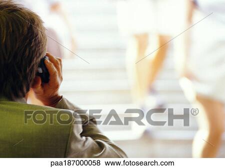 Businessman using cell phone, rear view, blurred View Large Photo Image Stock Photo - Businessman using cell phone, rear view, blurred. Fotosearch