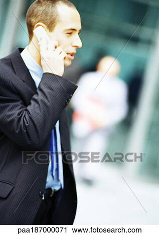 Businessman using cell phone, side view View Large Photo Image Stock Image - Businessman using cell phone, side view. Fotosearch