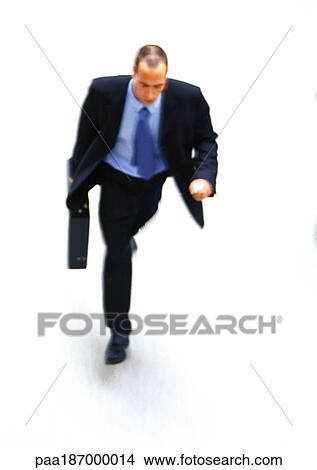 Businessman walking with briefcase in hand, elevated view View Large Photo Image Picture - Businessman walking with briefcase in hand, elevated view. Fotosearch