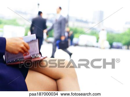 Businesswoman holding agenda on lap, close-up View Large Photo Image Picture - Businesswoman holding agenda on lap, close-up. Fotosearch