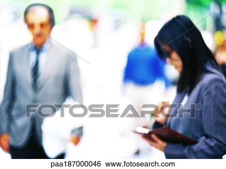 Businesswoman holding book, side view, blurred View Large Photo Image Stock Photograph - Businesswoman holding book, side view, blurred. Fotosearch