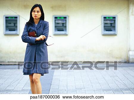 Businesswoman in front of cash machines View Large Photo Image Stock Photograph - Businesswoman in front of cash machines. Fotosearch