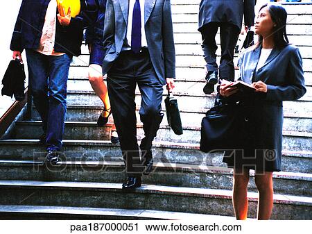 Stock Image - Businesswoman taking notes in front of stairs. Fotosearch