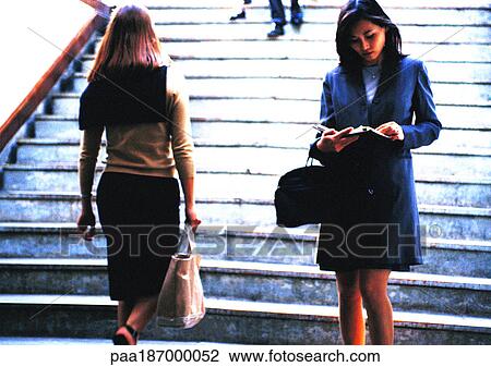 Businesswoman taking notes in front of stairs View Large Photo Image Stock Image - Businesswoman taking notes in front of stairs. Fotosearch