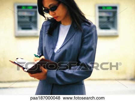 Businesswoman taking notes in the street View Large Photo Image Stock Photo - Businesswoman taking notes in the street. Fotosearch