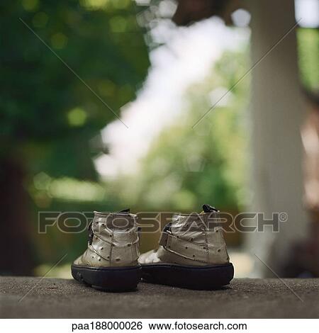 Stock Photograph - A pair of child's shoes sitting on ground.. Fotosearch