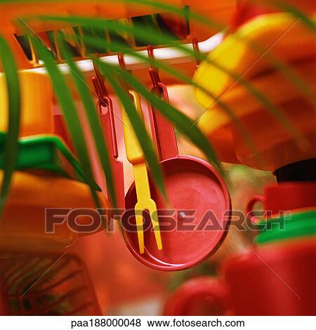 Plastic kitchenware hanging from shelf. View Large Photo Image Stock Photo - Plastic kitchenware hanging from shelf.. Fotosearch