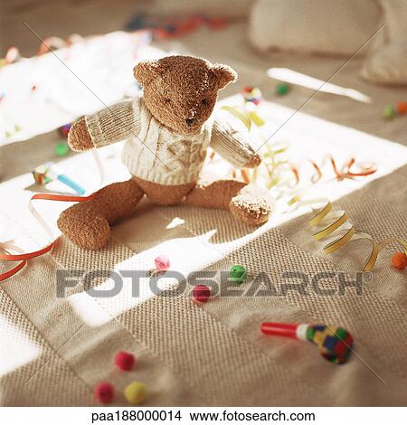 Stuffed teddy bear on floor with party favors. View Large Photo Image Picture - Stuffed teddy bear on floor with party favors.. Fotosearch