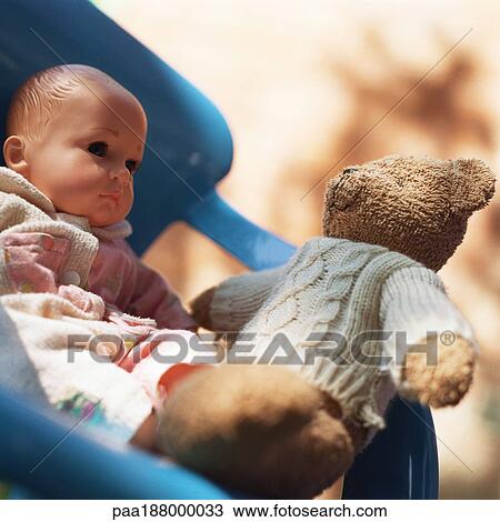 Teddy bear sitting in chair with baby doll. View Large Photo Image Stock Image - Teddy bear sitting in chair with baby doll.. Fotosearch