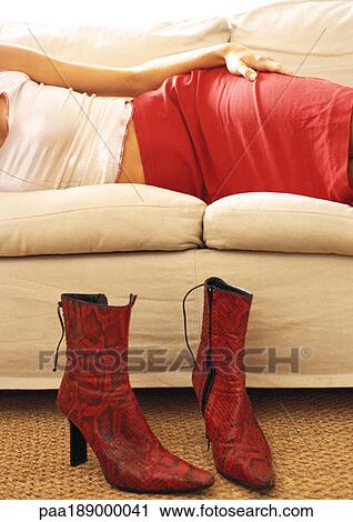 Mid section of woman lying on couch, boots on floor View Large Photo Image Stock Image - Mid section of woman lying on couch, boots on floor. Fotosearch