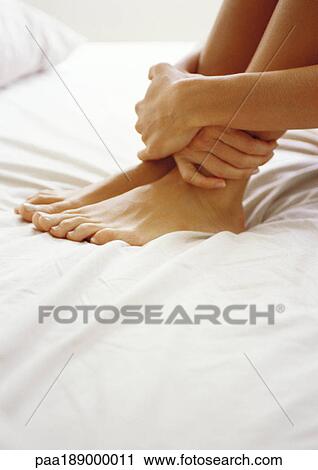 Woman holding ankles, close up. View Large Photo Image Stock Image - Woman holding ankles, close up.. Fotosearch