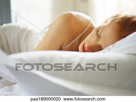 Stock Image - Woman lying in bed, close up.. Fotosearch