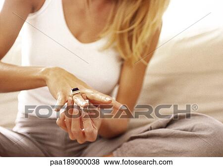 Woman putting ring on finger, mid-section, close up. View Large Photo Image Stock Photo - Woman putting ring on finger, mid-section, close up.. Fotosearch