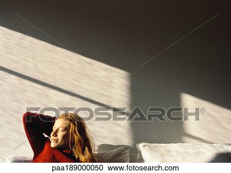 Woman sitting on couch, eyes closed. View Large Photo Image Stock Image - Woman sitting on couch, eyes closed.. Fotosearch