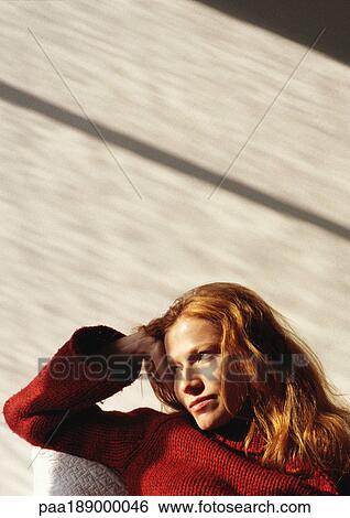 Woman sitting on couch looking away View Large Photo Image Stock Photograph - Woman sitting on couch looking away. Fotosearch