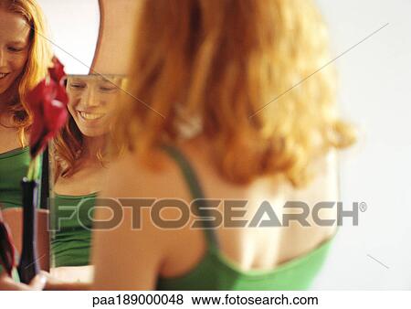 Woman standing in front of mirror, smiling. View Large Photo Image Stock Photo - Woman standing in front of mirror, smiling.. Fotosearch