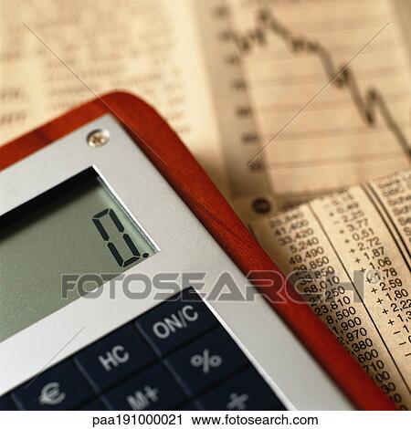 Stock Image - Calculator on top of financial charts.. Fotosearch