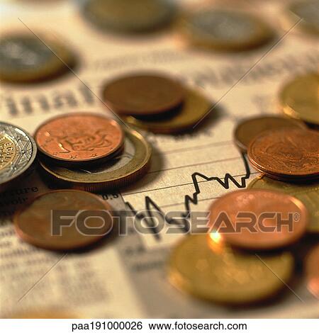 Stock Photograph - Coins on top of financial charts.. Fotosearch