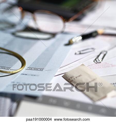 Picture - Paperwork, glasses and office materials lying on desk.. Fotosearch