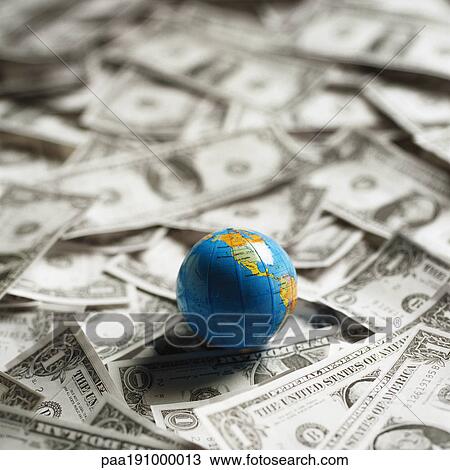 Small world globe on top of U. S. Dollars. View Large Photo Image Stock Image - Small world globe on top of U. S. Dollars.. Fotosearch