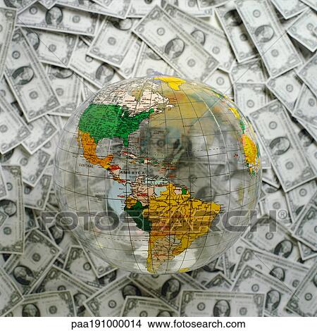Picture - World globe on top of U. S. Dollars.. Fotosearch