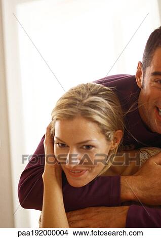 Picture - Man hugging woman from behind. Fotosearch