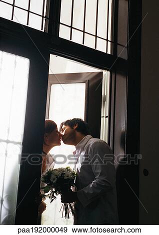 Man kissing woman in doorway, tilt View Large Photo Image Stock Photo - Man kissing woman in doorway, tilt. Fotosearch