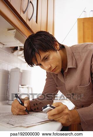 Man looking at classified ads in newspaper and holding cell phone. View Large Photo Image Stock Image - Man looking at classified ads in newspaper and holding cell phone.. Fotosearch
