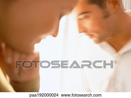 Picture - Man looking away from woman, blurred close up.. Fotosearch
