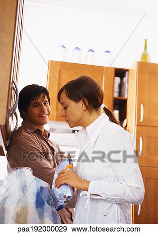 Man smiling at woman in kitchen. View Large Photo Image Stock Photo - Man smiling at woman in kitchen.. Fotosearch