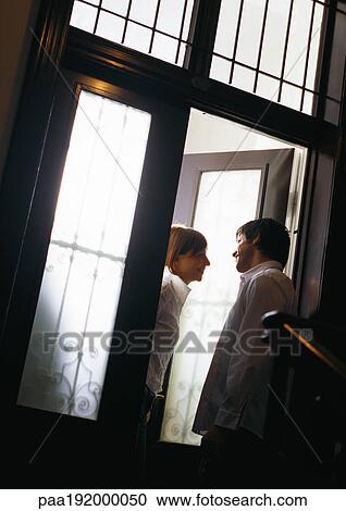 Man talking to woman in doorway, tilt View Large Photo Image Stock Image - Man talking to woman in doorway, tilt. Fotosearch