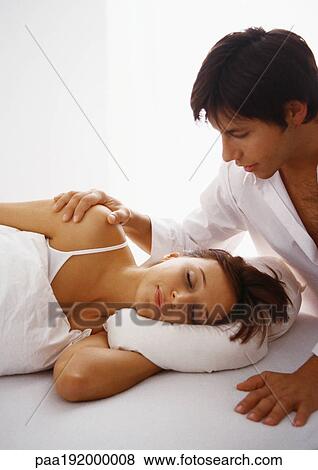 Stock Photo - Man touching woman lying in bed.. Fotosearch
