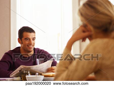 Woman sitting across from man at table, rear view. View Large Photo Image Stock Image - Woman sitting across from man at table, rear view.. Fotosearch
