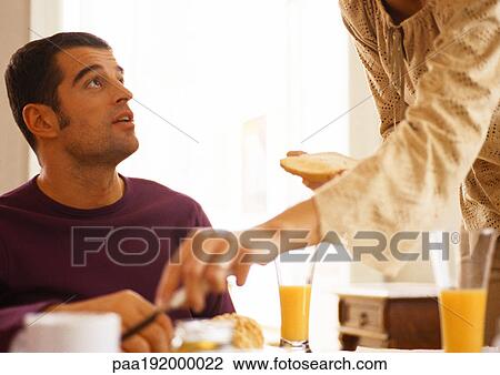 Woman with toast standing above man at table. View Large Photo Image Stock Image - Woman with toast standing above man at table. . Fotosearch