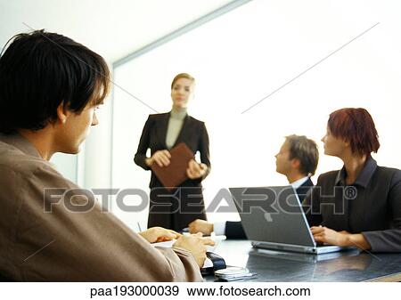 Business people around table looking at businesswoman standing. View Large Photo Image Stock Photo - Business people around table looking at businesswoman standing.. Fotosearch