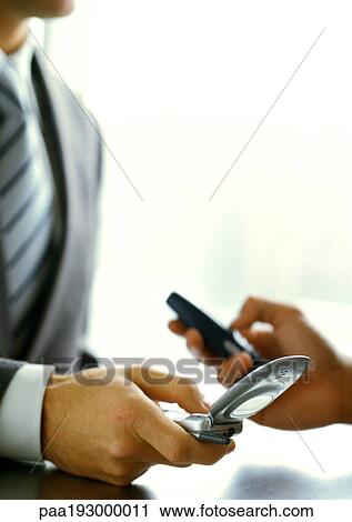 Business people's hands, exchanging numbers with cell phones, close-up. View Large Photo Image Stock Image - Business people's hands, exchanging numbers with cell phones, close-up.. Fotosearch