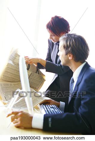 Businessman and businesswoman looking at newspaper. View Large Photo Image Stock Image - Businessman and businesswoman looking at newspaper.. Fotosearch