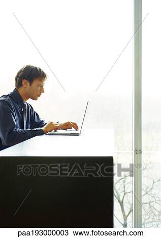 Businessman sitting at desk working on computer. View Large Photo Image Stock Image - Businessman sitting at desk working on computer.. Fotosearch