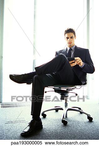 Stock Photography - Businessman sitting in chair. Fotosearch