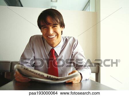 Businessman smiling at camera, holding newspaper, head and shoulders. View Large Photo Image Picture - Businessman smiling at camera, holding newspaper, head and shoulders.. Fotosearch