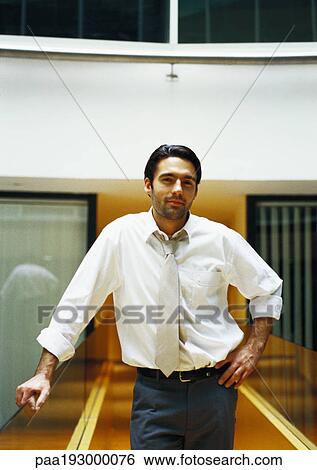 Businessman standing, hand on hip. View Large Photo Image Stock Photograph - Businessman standing, hand on hip.. Fotosearch