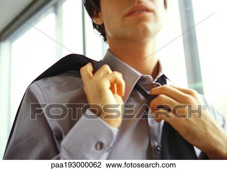 Businessman undoing tie, close-up, low angle view. View Large Photo Image Stock Image - Businessman undoing tie, close-up, low angle view.. Fotosearch