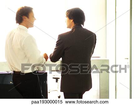 Businessmen standing, talking side by side. View Large Photo Image Stock Photography - Businessmen standing, talking side by side.. Fotosearch